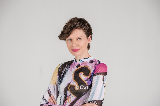 A person with short hair wearing a colorful shirt
Description automatically generated